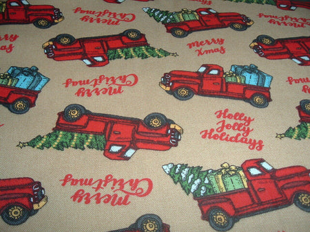Regalos navideños con un camión rojo y árboles en tela de algodón 100 % de color beige. Precio por yarda.