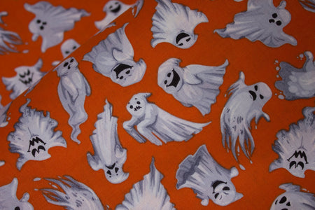 Tela de algodón 100 % naranja con fantasmas voladores de Halloween. Precio por yarda.