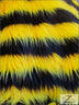 Tela de piel sintética de pelo largo a rayas bicolores, en negro y amarillo