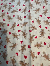 Mini estampado navideño vintage de galletas de jengibre y corazones sobre fondo crema, 100 % algodón ligero. Precio por yarda.