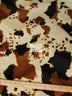 Tejido de felpa de pelo corto con estampado de vaca en colores marrón, negro y blanco roto / Se vende por metros