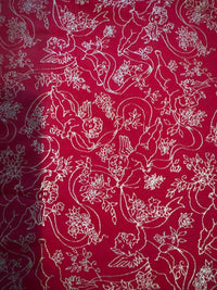 Estampado vintage en dorado metalizado con querubines, ángeles y cintas sobre fondo rojo, 100 % algodón ligero. Precio por yarda.