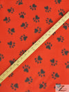 Tejido de felpa con estampado de huellas de animales en rojo y negro