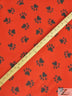 Tejido de felpa con estampado de huellas de animales en rojo y negro