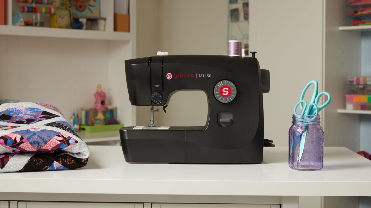 The SINGER® M1150 Black Sewing Machine offers a simple, modern design that complements any room décor. Ease-of-use features include a top drop-in bobbin and simple stitch selection with preset stitch length and width, making this a perfect choice for the beginning sewist.