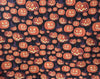 Calabaza sonriente de Halloween «Jack o’Lantern» con sombreros de bruja sobre tela negra 100 % algodón
