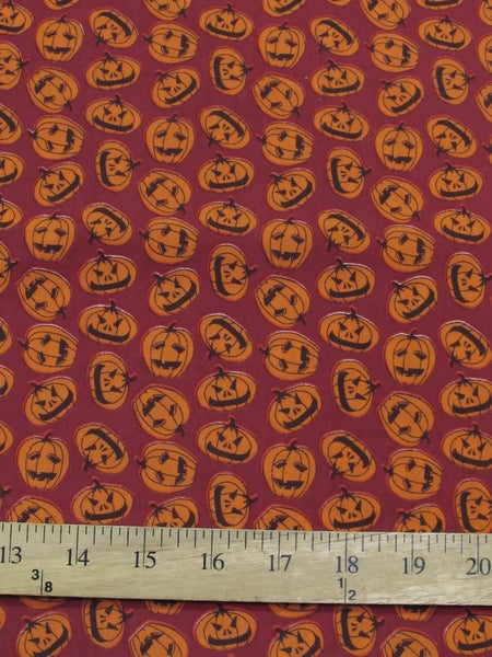 Tela de poliéster y algodón color burdeos con motivos de calabazas de Halloween