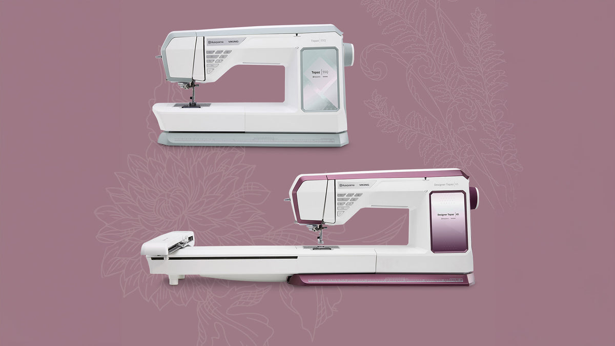 Two white sewing machines on a pink background with floral patterns.